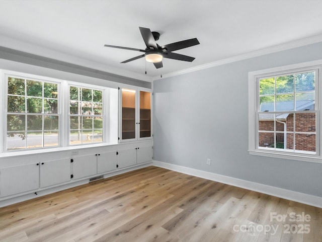 spare room with ceiling fan, crown molding, and light hardwood / wood-style flooring