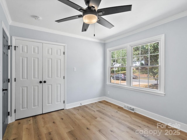 unfurnished bedroom featuring ceiling fan, a closet, crown molding, and light hardwood / wood-style flooring