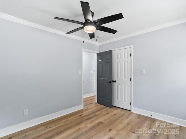 unfurnished bedroom featuring ceiling fan, a closet, ornamental molding, and light hardwood / wood-style flooring