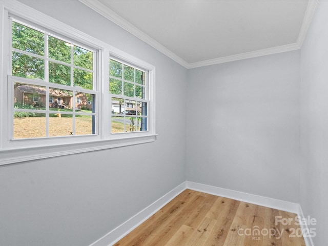 empty room with ornamental molding and light hardwood / wood-style floors