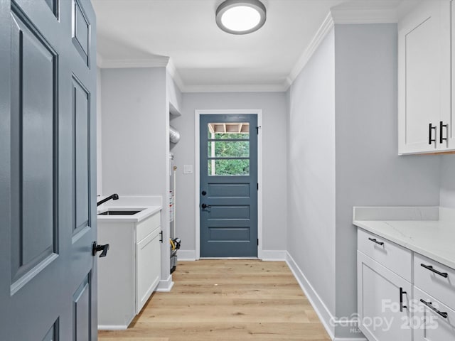 interior space featuring crown molding, light hardwood / wood-style flooring, and sink