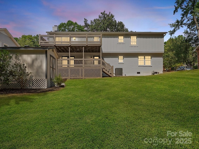 back house at dusk with a deck, central air condition unit, and a yard