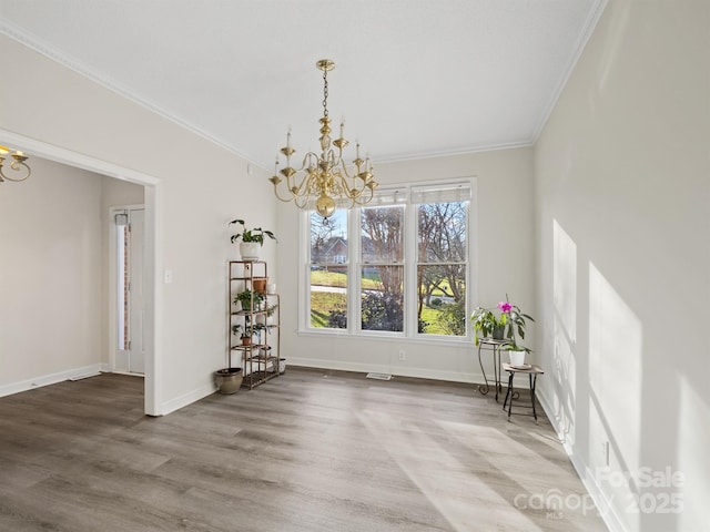 unfurnished dining area with a notable chandelier, wood-type flooring, and ornamental molding