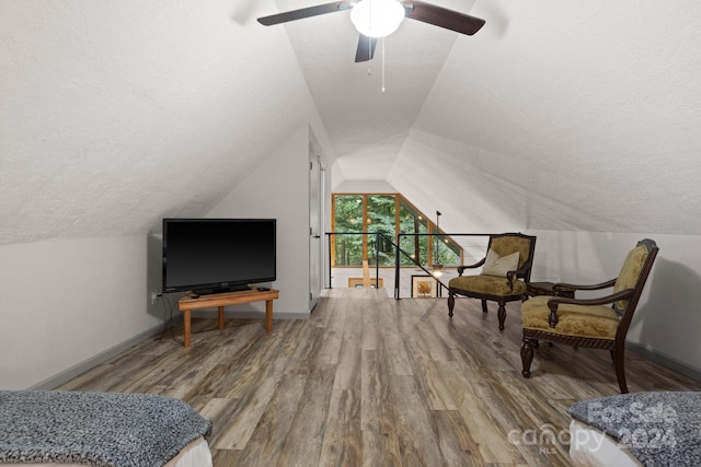 sitting room featuring lofted ceiling, hardwood / wood-style flooring, ceiling fan, and a textured ceiling