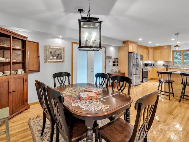 dining area with sink, light hardwood / wood-style floors, and french doors