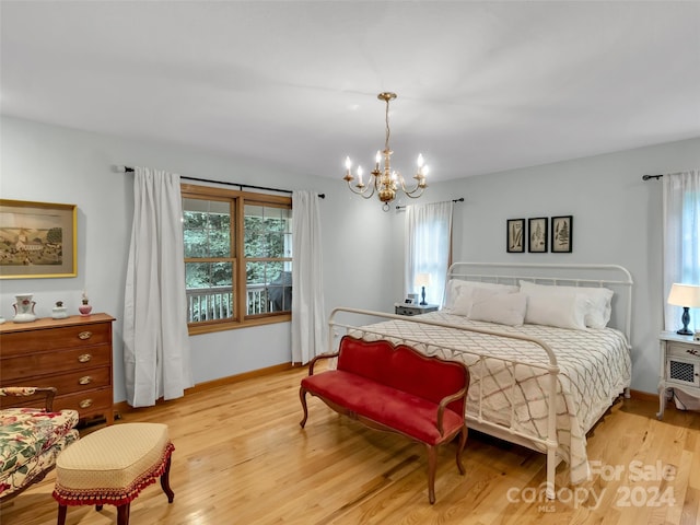 bedroom with a notable chandelier and light hardwood / wood-style floors