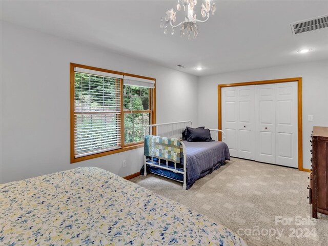 carpeted bedroom with a chandelier and a closet