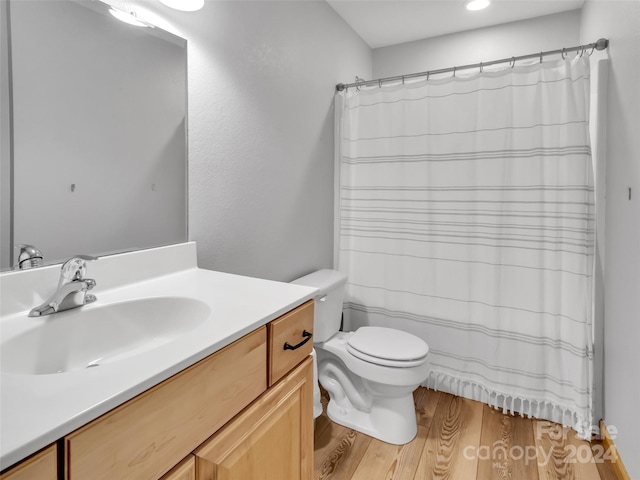 bathroom with vanity, toilet, a shower with curtain, and hardwood / wood-style flooring