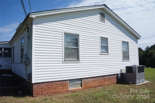 view of home's exterior with a yard and cooling unit