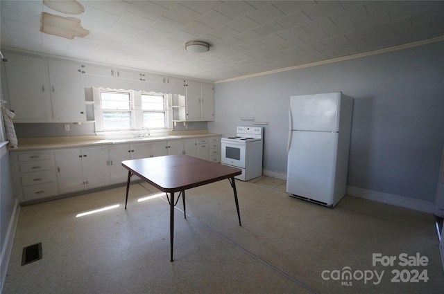 kitchen featuring crown molding, white appliances, and white cabinetry