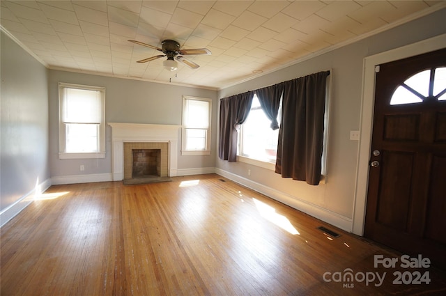 unfurnished living room featuring ceiling fan, a wealth of natural light, light hardwood / wood-style floors, and crown molding