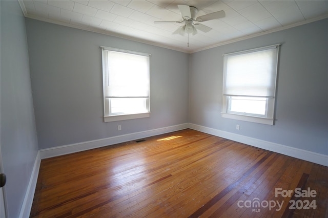 empty room featuring crown molding, wood-type flooring, and ceiling fan