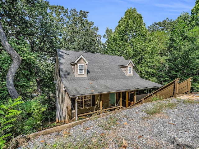 view of front facade featuring a porch and roof with shingles