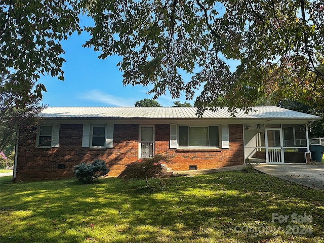 single story home with a front yard, a sunroom, crawl space, brick siding, and metal roof