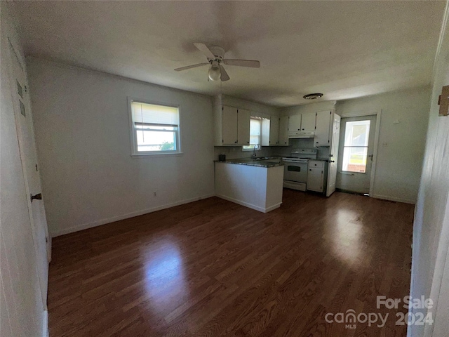 kitchen featuring dark wood-type flooring, dark countertops, white electric stove, a peninsula, and white cabinets