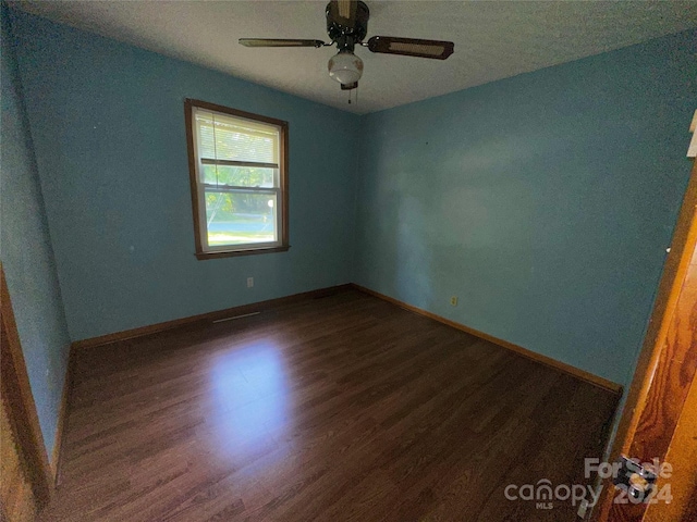 unfurnished room with baseboards, wood finished floors, and a ceiling fan