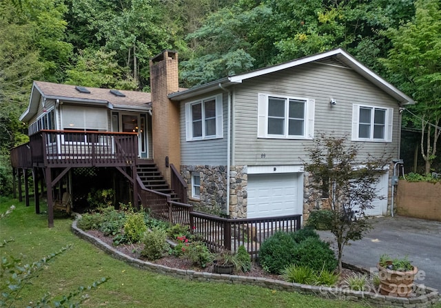 back of house featuring a yard, a garage, and a deck