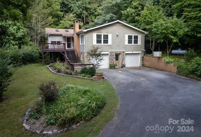 view of front facade featuring a front yard, a garage, and a deck