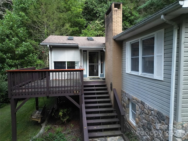 view of exterior entry featuring a wooden deck