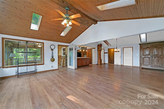 unfurnished living room with ceiling fan with notable chandelier, high vaulted ceiling, a skylight, and beam ceiling