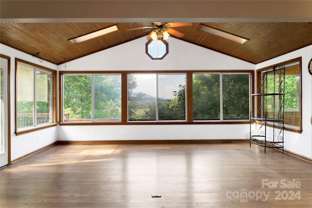 unfurnished sunroom featuring ceiling fan, vaulted ceiling with skylight, and wooden ceiling