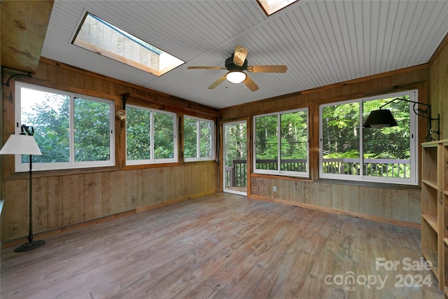 unfurnished sunroom with a wealth of natural light, ceiling fan, and a skylight