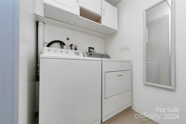 laundry room with light tile patterned floors, cabinets, and independent washer and dryer