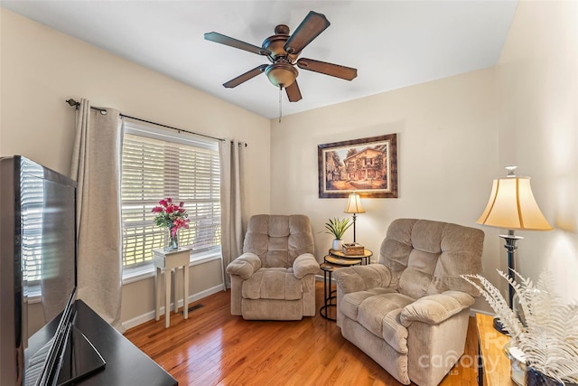 living room with ceiling fan and light hardwood / wood-style flooring