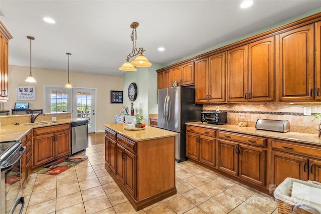 kitchen with light tile patterned floors, a center island, appliances with stainless steel finishes, pendant lighting, and tasteful backsplash