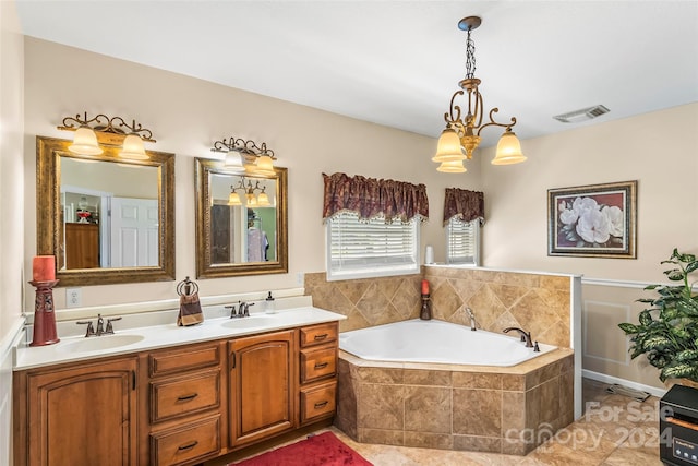 bathroom featuring tile patterned floors, tiled tub, and vanity