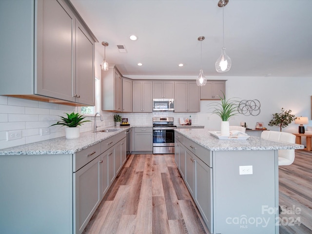 kitchen with light hardwood / wood-style flooring, stainless steel appliances, gray cabinetry, and sink