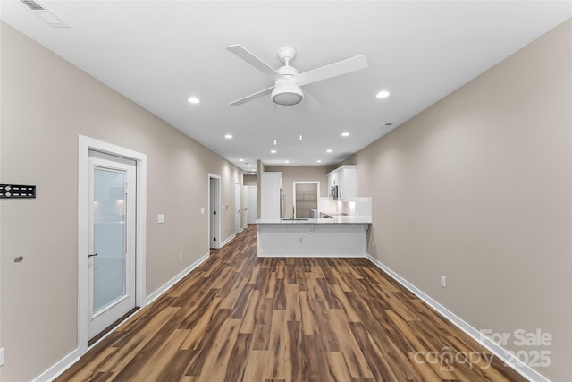 unfurnished living room featuring dark hardwood / wood-style floors and ceiling fan