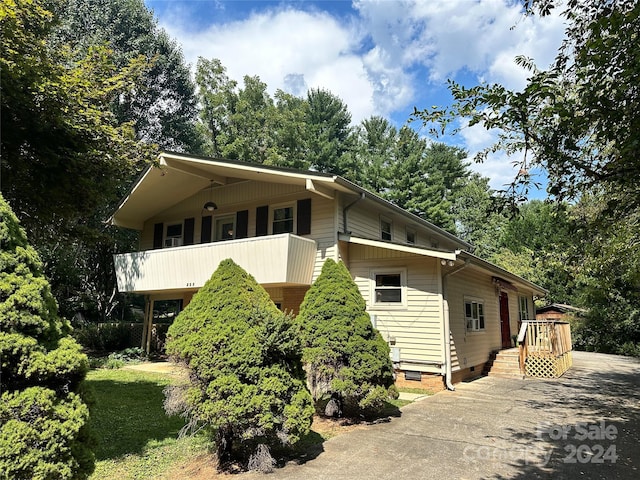 view of side of property featuring a balcony and crawl space