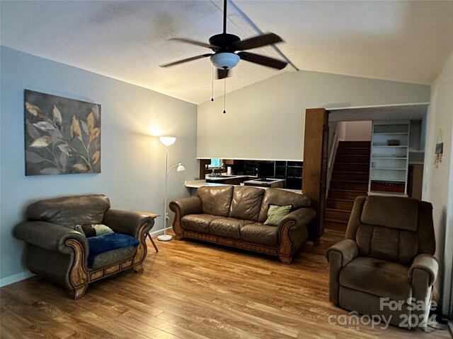 living room featuring lofted ceiling, ceiling fan, and wood-type flooring