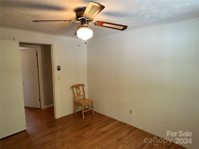 unfurnished room with a textured ceiling, hardwood / wood-style flooring, and ceiling fan