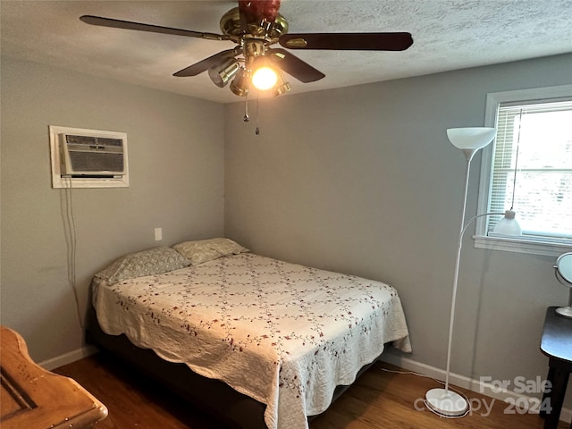 bedroom featuring a textured ceiling, ceiling fan, and dark hardwood / wood-style floors