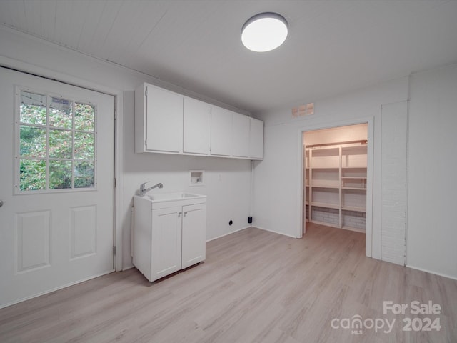 laundry area featuring light wood-type flooring, washer hookup, cabinet space, electric dryer hookup, and a sink