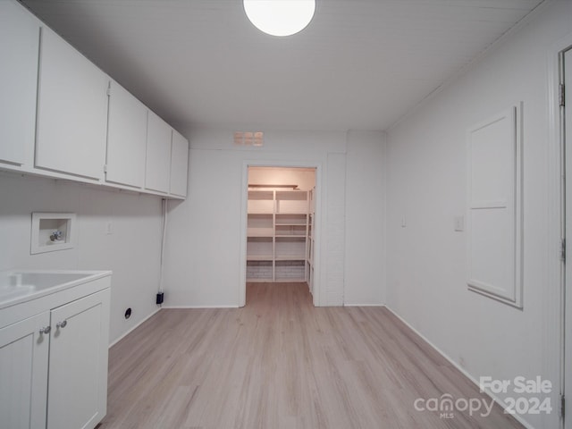 washroom featuring hookup for a washing machine, cabinets, and light hardwood / wood-style floors