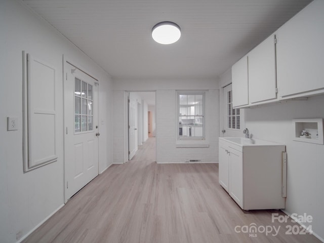 washroom with hookup for a washing machine, visible vents, cabinet space, a sink, and light wood-type flooring