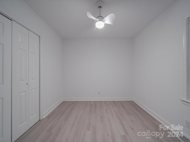 unfurnished bedroom with light wood-type flooring, ceiling fan, and a closet