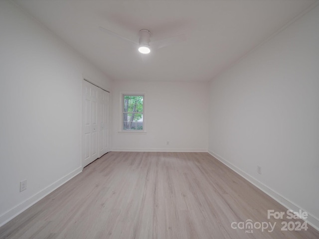 spare room with a ceiling fan, baseboards, and light wood finished floors