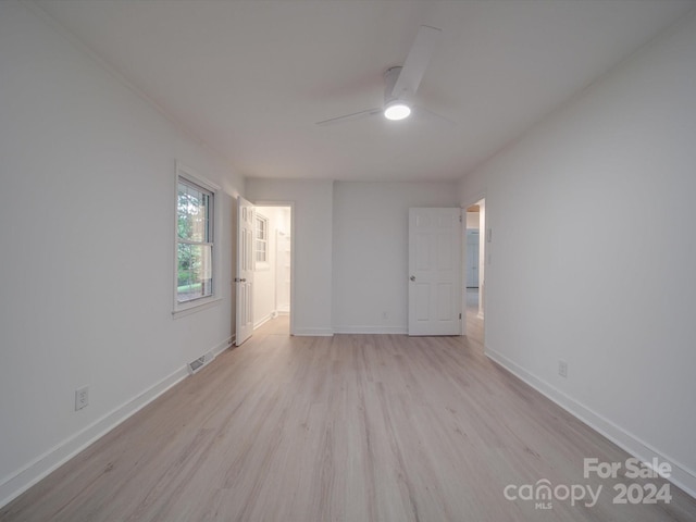 unfurnished room with light wood-type flooring, baseboards, visible vents, and a ceiling fan