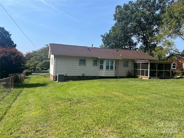 back of property with central air condition unit and a yard