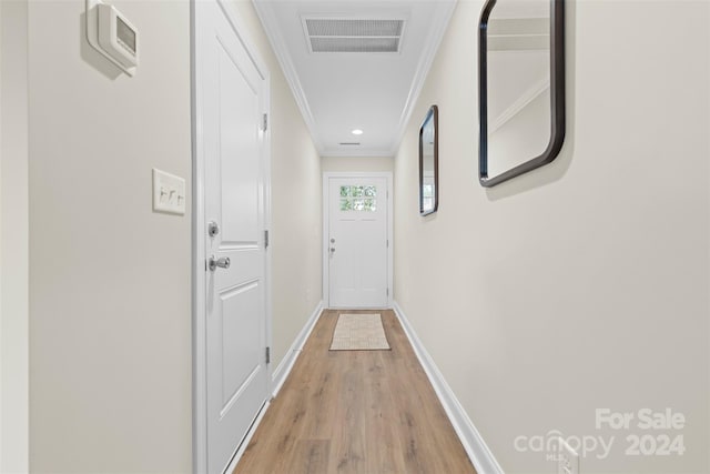 corridor with crown molding and light hardwood / wood-style flooring