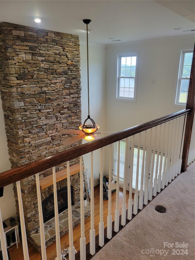 stairs featuring wood-type flooring, a fireplace, and a healthy amount of sunlight