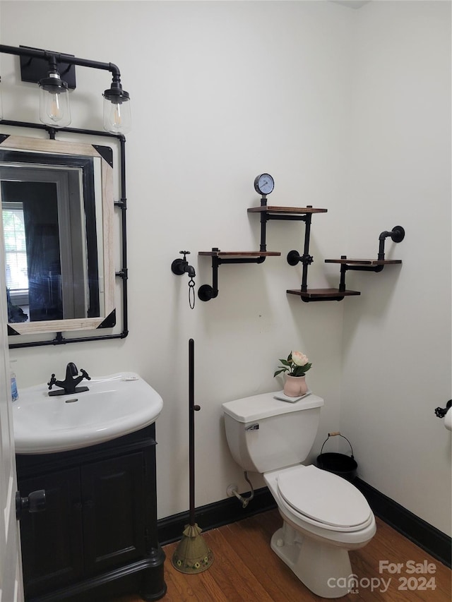 bathroom featuring vanity, wood-type flooring, and toilet