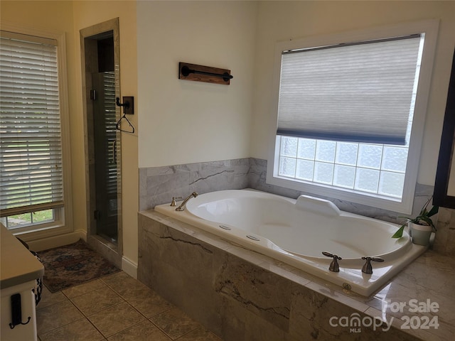 bathroom featuring tile patterned floors, plus walk in shower, and plenty of natural light