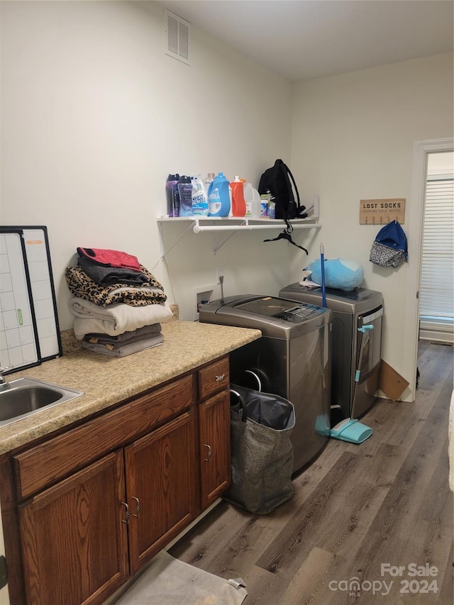 laundry area featuring sink, washer and dryer, cabinets, and dark hardwood / wood-style flooring