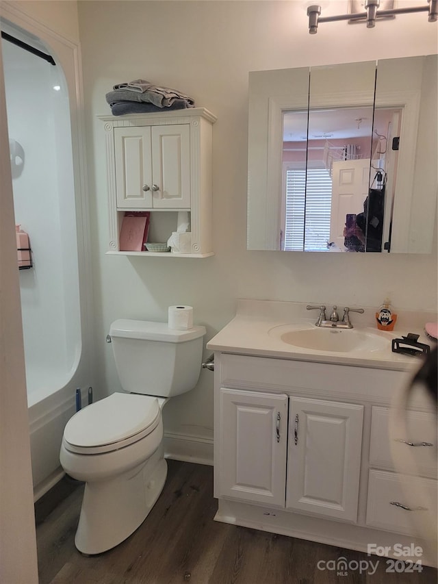 full bathroom featuring toilet, vanity, wood-type flooring, and separate shower and tub