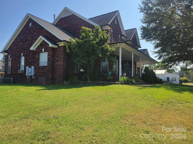 view of side of home featuring central AC and a lawn